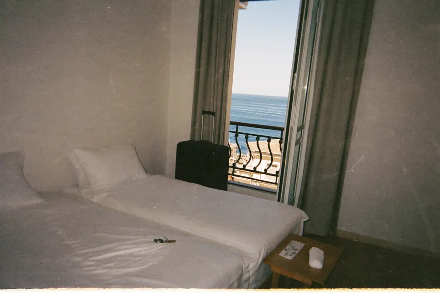 Studio meublé avec valise et balcon ouvert sur la mer